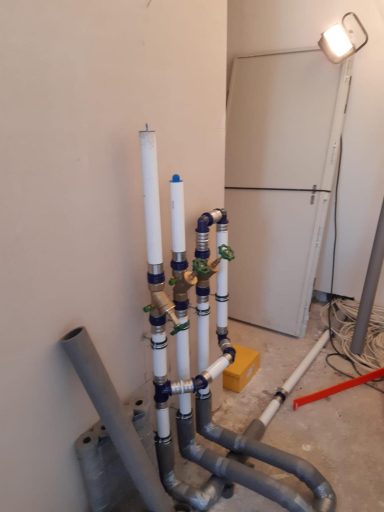 Mehrere senkrechte Rohrleitungen mit Ventilen und Anschlüssen für eine Heizungs- oder Sanitärinstallation.