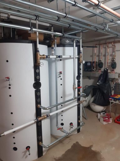 Zwei große Warmwasser- oder Pufferspeicher mit angeschlossener Heizungs- und Rohrtechnik.
