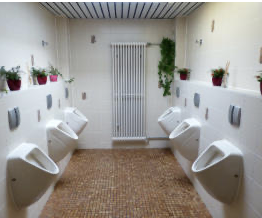 Sanitärraum mit mehreren Urinalen und Heizkörper als Referenz für Sanitärinstallationen in öffentlichen oder gewerblichen Gebäuden.