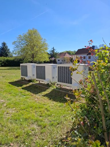 Mehrere installierte Luft-Wasser-Wärmepumpen im Außenbereich eines Wohngebäudes als Referenz für moderne Heiztechnik.